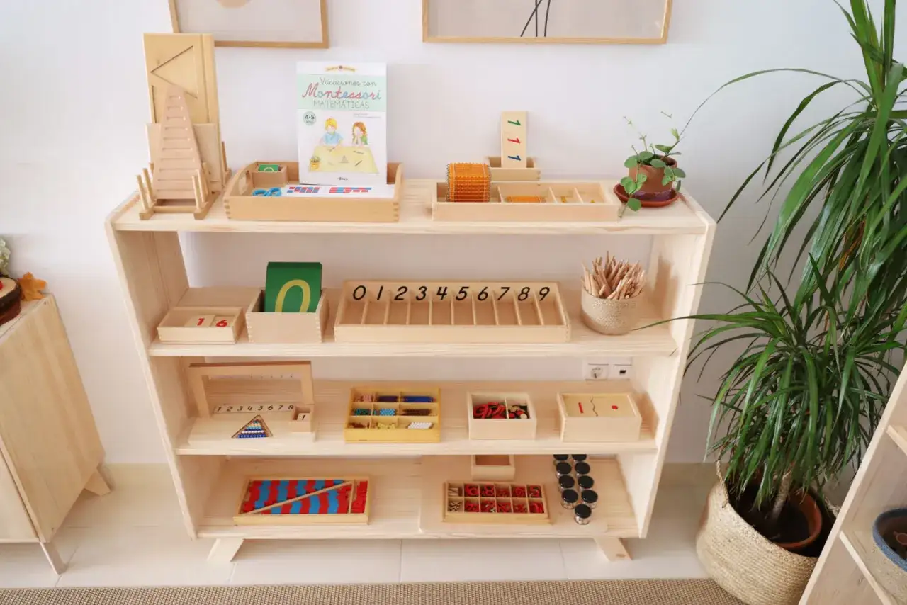 Estantería con materiales de matemáticas, como ejemplo de método Montessori. Incluye cuentas, números y tarjetas.